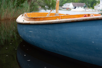 Close view of a small sailboat floating on a populated waterway