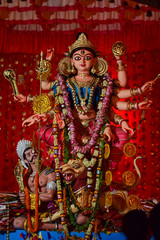 Fototapeta premium Idol of Goddess Devi Durga at a decorated puja pandal in Kolkata, West Bengal, India. Durga Puja is a famous and major religious festival of Hinduism that is celebrated throughout the world.