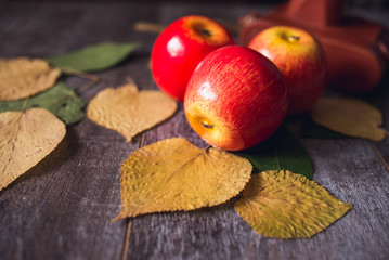 autumn red apples on wooden table and hat