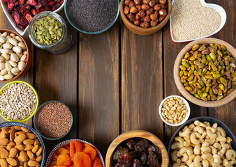 nuts, seeds and dried fruis on wooden surface