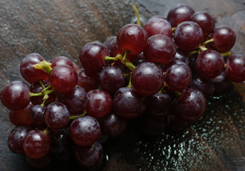 The bunch of red grape on wooden floor