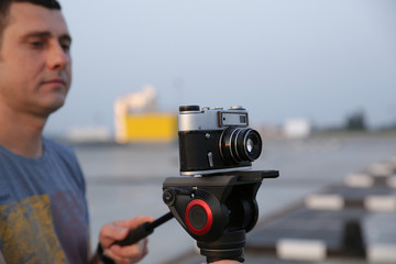 Close-up Old vintage camera on a modern monopod in the hand of a photographer or videographer....