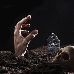 Hand sticking out of ground nearÂ headstone