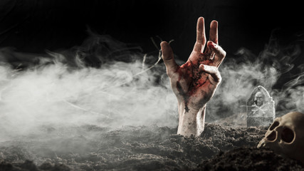 Blood hand sticking out of ground in fog