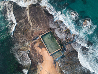 Top down aerial view of Mona Vale rock pool with wave around.