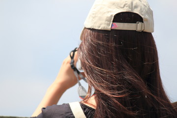 A woman is taking a photo in front of beautiful lake.