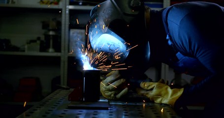 Close-up portrait of a male welder close-up who welds a part.