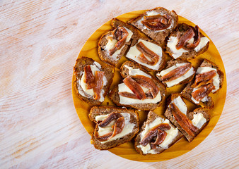 Canapes of bread with butter and salted anchovies