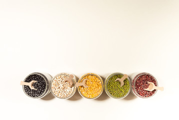 Assortment of beans and lentils in wooden bowl and spoon on clear background. mung bean, groundnut, soybean, red kidney bean , black bean ,red bean and brown pinto beans .