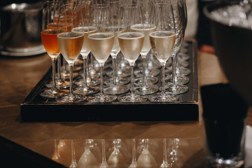 Pouring champagne into wine glasses. Champagne flutes on a wedding or new year eve party