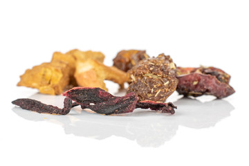 Group of nine pieces of raisins roseship hibiscus of lingonberry strawberry fruit tea macro isolated on white background
