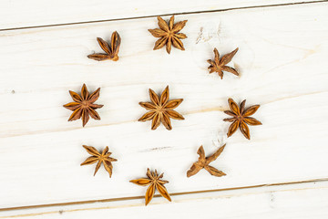 Lot of whole dry brown star anise illicium verum flatlay on white wood