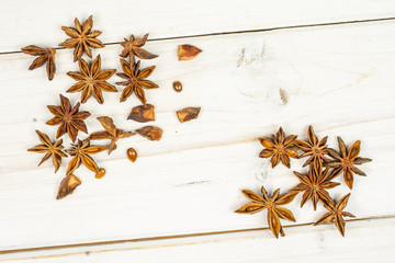 Lot of whole lot of pieces of dry brown star anise illicium verum flatlay on white wood