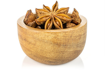 Lot of whole dry brown star anise illicium verum in tiny wooden bowl isolated on white background