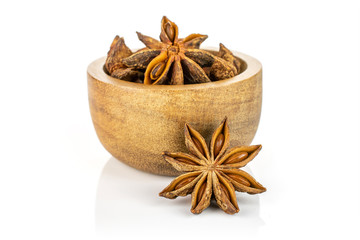 Lot of whole dry brown star anise illicium verum in tiny wooden bowl isolated on white background