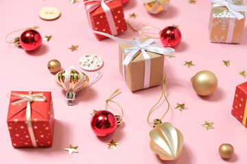 Christmas background with decorations and gift boxes on pink background
