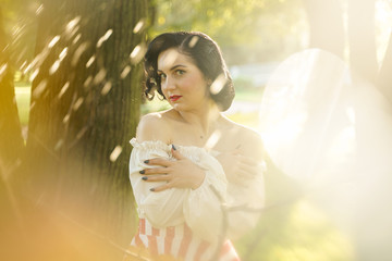 young beautiful caucasian woman posing in retro styling. pin up girl in white shirt at sunset evening.