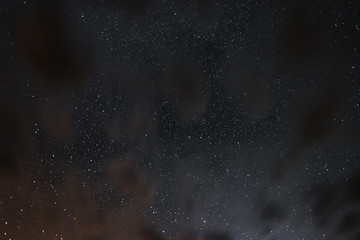 Stars in the night sky through the clouds on a summer night