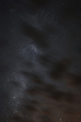 Milky way in the night sky through the clouds on a summer night