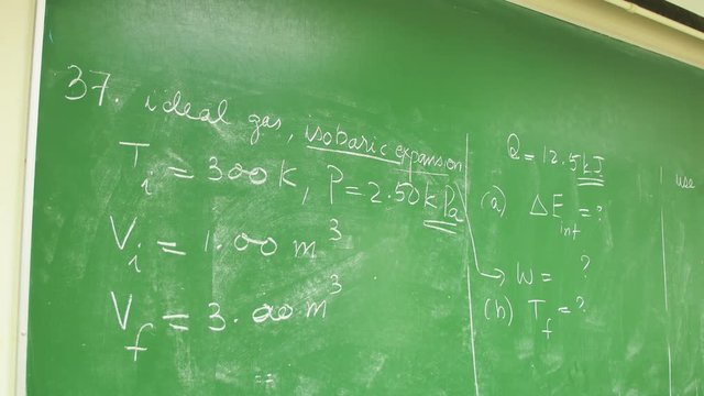 Mathematics Physics formulas on green blackboard in university.First out of focus then sharp image. Rack Focus.
Mathematik Physik Formeln auf Tafe