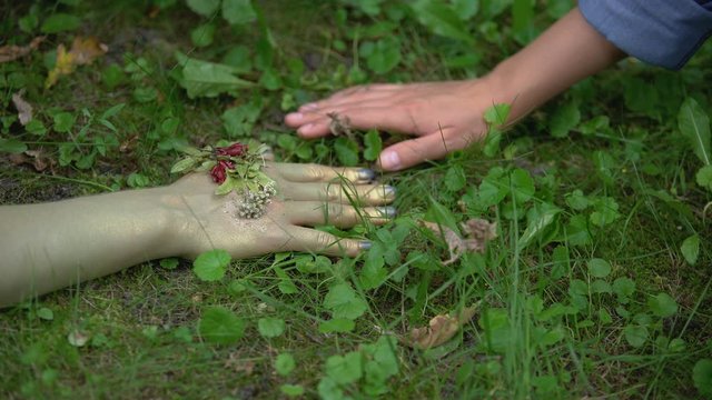 Woman holding earth mother hand on forest ground, life giving power, nature