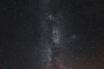 Milky way in the night sky through the clouds on a summer night