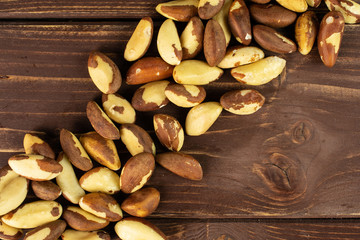 Lot of whole raw brown brazil nut flatlay on brown wood