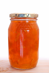 A bottle of glowing marmalade against a white background isolated