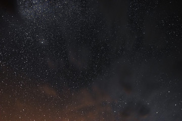 Stars in the night sky through the clouds on a summer night