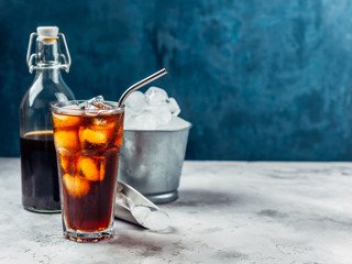 Cold brew coffee in a glass with metal straw on a dark background.Iced coffee