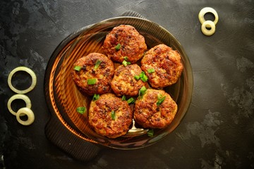 Meat cutlets. Cutlets in a pan on a black concrete table background. Delicious tasty food. Cutlets in the black plate isolated.