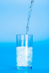 Close up pouring purified fresh drink water from the bottle on table