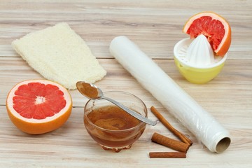 Cellulite treatment from honey, cinnamon and grapefruit juice. Ingredients for homemade anti cellulite wrap on the table