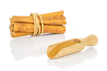 Group of six whole dry brown cinnamon wrapped in natural twine in a wooden scoop isolated on white background