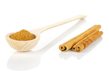 Group of two whole dry brown cinnamon in a wooden spoon isolated on white background