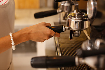 Close up of female barista wearing bracelet making coffee
