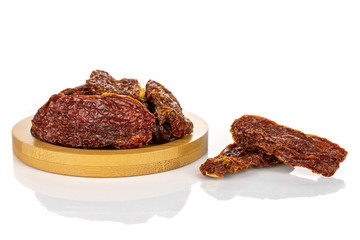 Lot of whole dried red tomato on round bamboo coaster isolated on white background