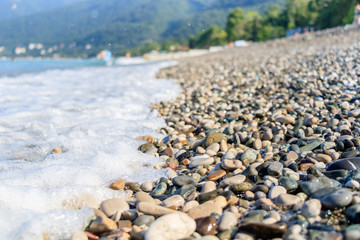 rest on the sea, pebble beach and waves, near the mountains