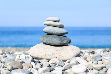 balance of stones on the background of the sea and the beach, the concept of harmony and relaxation, close-up