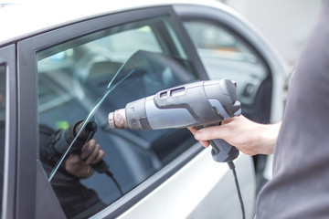 Removing old film car glass foil with heat shrink gun.