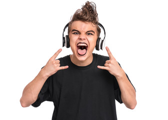 Teen boy in headphones with spooking make-up making Rock Gesture, isolated on white background....