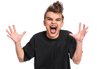 Fototapeta premium Rebellious teen boy dressed in black, isolated on white background. Angry screaming teenager in style of punk goth wearing black t-shirt, shouting. Problems of transitional age.