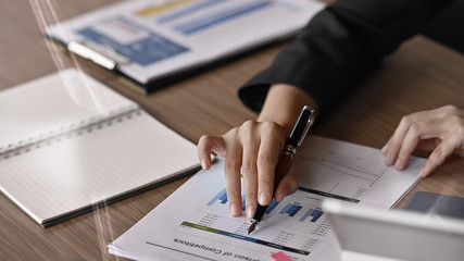 Fototapeta premium Closeup businesswoman analysis finance graph paper on table.