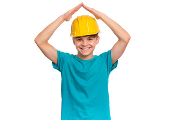 Portrait of smiling teen boy wearing yellow hard hat holding hands over head like roof house, isolated on white background. Beautiful student caucasian young teenager in helmet looking at camera.