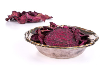Lot of slices of dried red beetroot in metal bowl isolated on white background