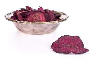 Obraz premium Lot of slices of dried red beetroot one is in the front and the rest is in metal bowl isolated on white background