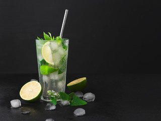 Cocktail Mojito with ice in a glass, lime, leaf mint ,shaker ice cubes and metal straw