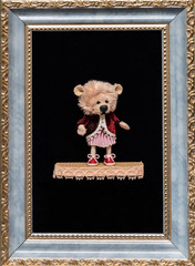 Puppet bear in an old kaftan in a picture frame