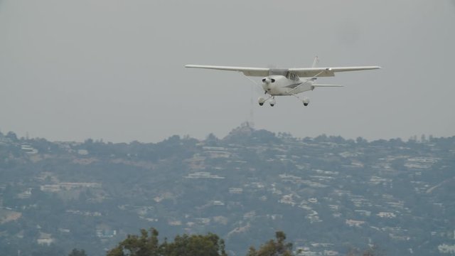 Small generic private propeller airplane preparing for landing, no tail or identification number. 60 FPS Slow Motion, 4K RAW graded footage