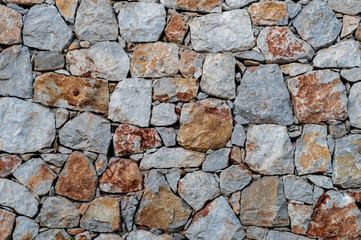Modern wall of large unprocessed pieces of rock, stones. Background stone wall.